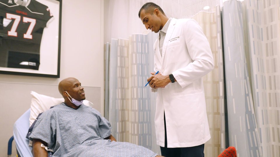 Dr. Tummala talking with a patient in the preoperative area